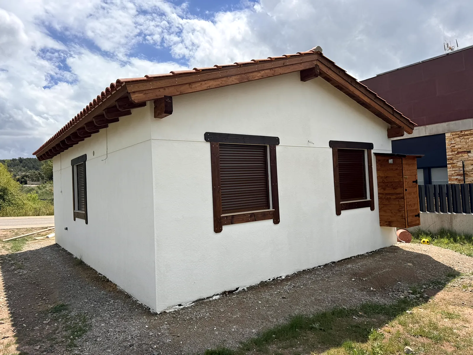 Casa de madera con fachada monocapa blanca y tejado de teja en Prades