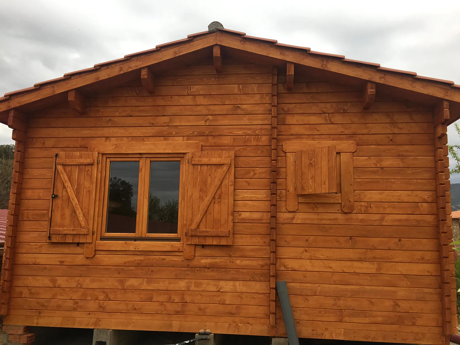 Casas de madera con sistema nórdico 5 Fachada de casa de madera maciza con contraventanas