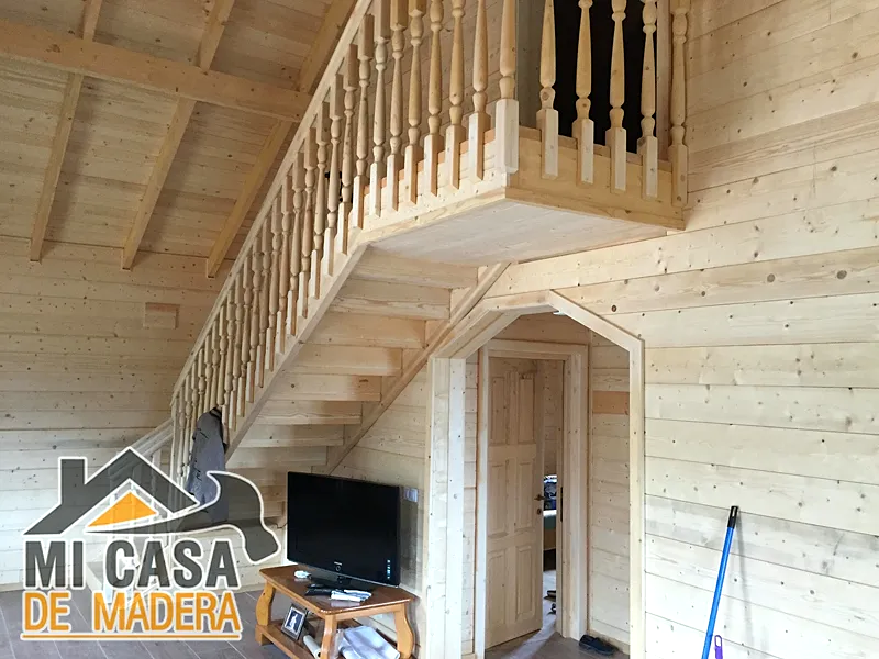 Casas de madera con sistema nórdico 7 Interior de casa de madera con escalera y madera vista