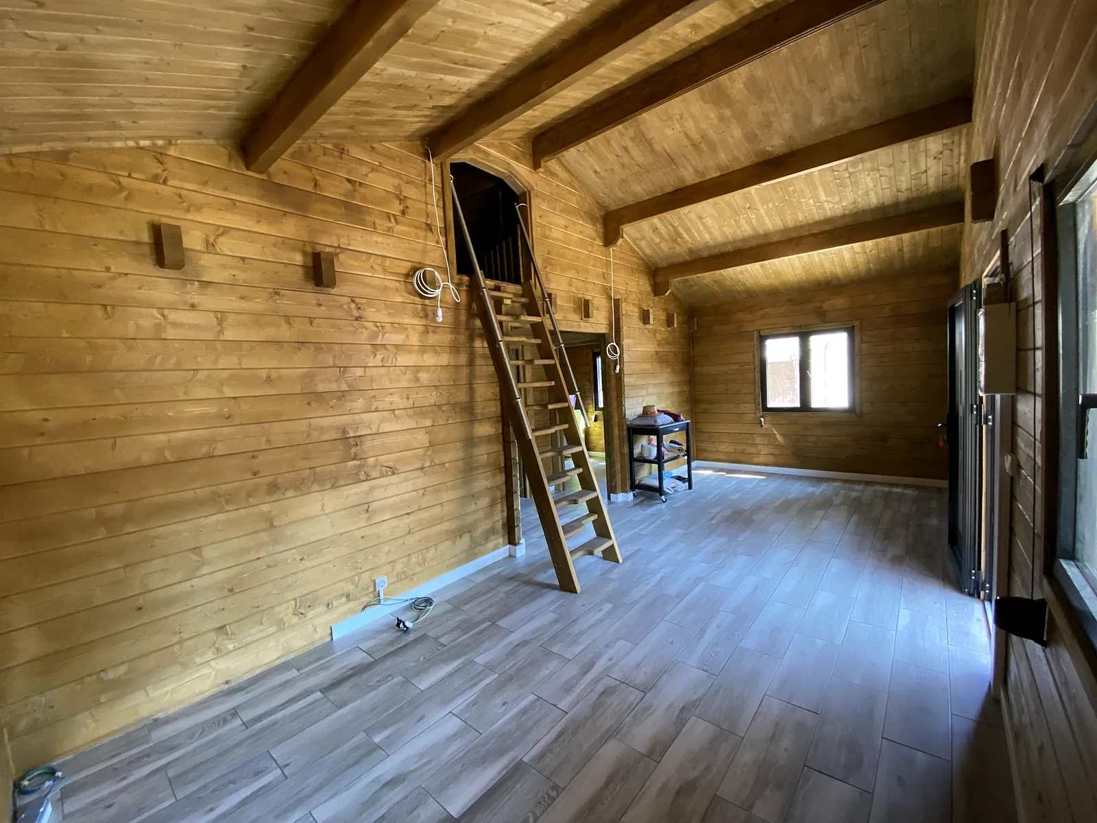 Casas de madera con sistema nórdico 11 Interior de una casa de madera maciza con vigas vistas y altillo
