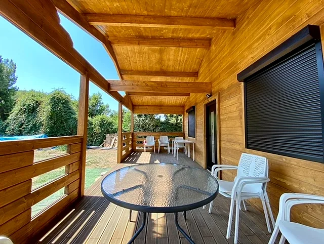 Casas de madera con sistema nórdico 10 Porche cubierto de una casa de madera maciza con techo de madera vista