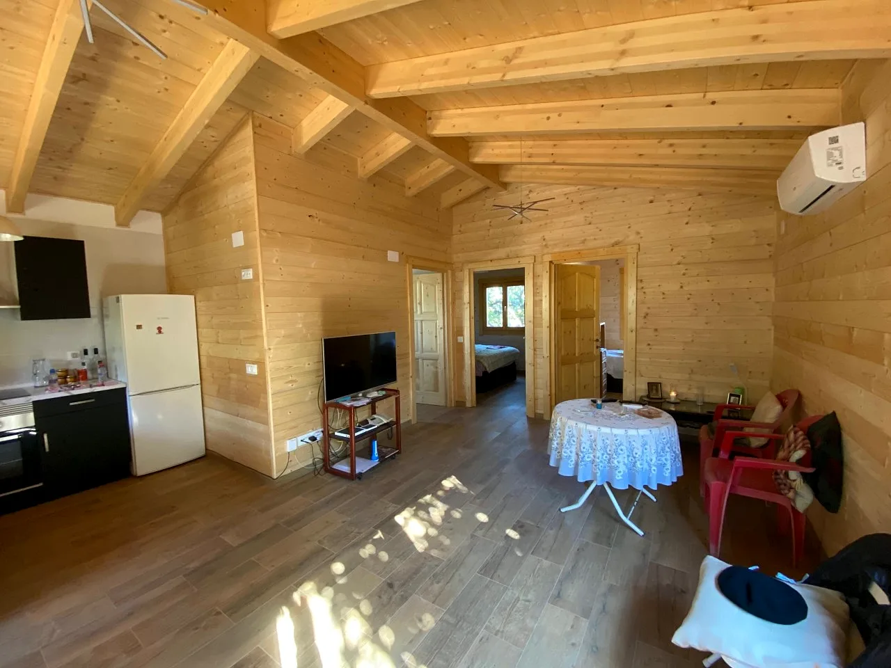 Casas de madera con sistema nórdico 15 Salón y cocina de una casa de madera maciza con techo de vigas vistas